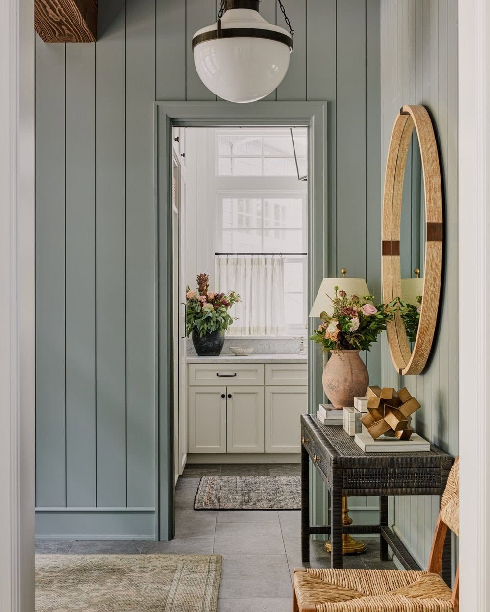 A hallway with a wooden table and a mirror.