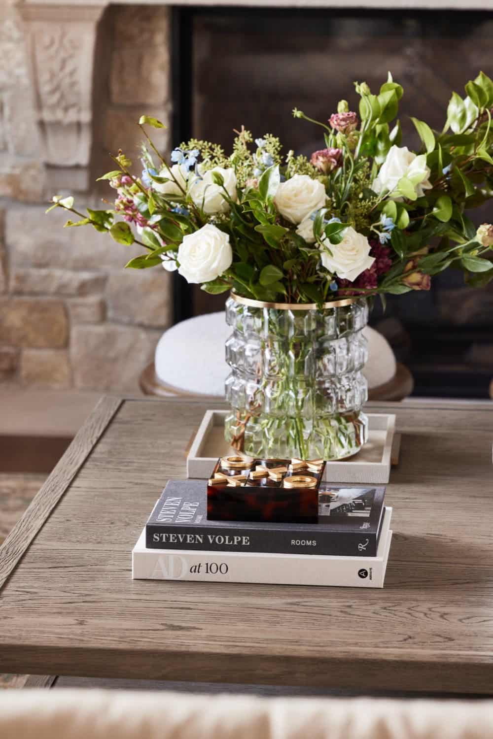 A coffee table with books and flowers on it.