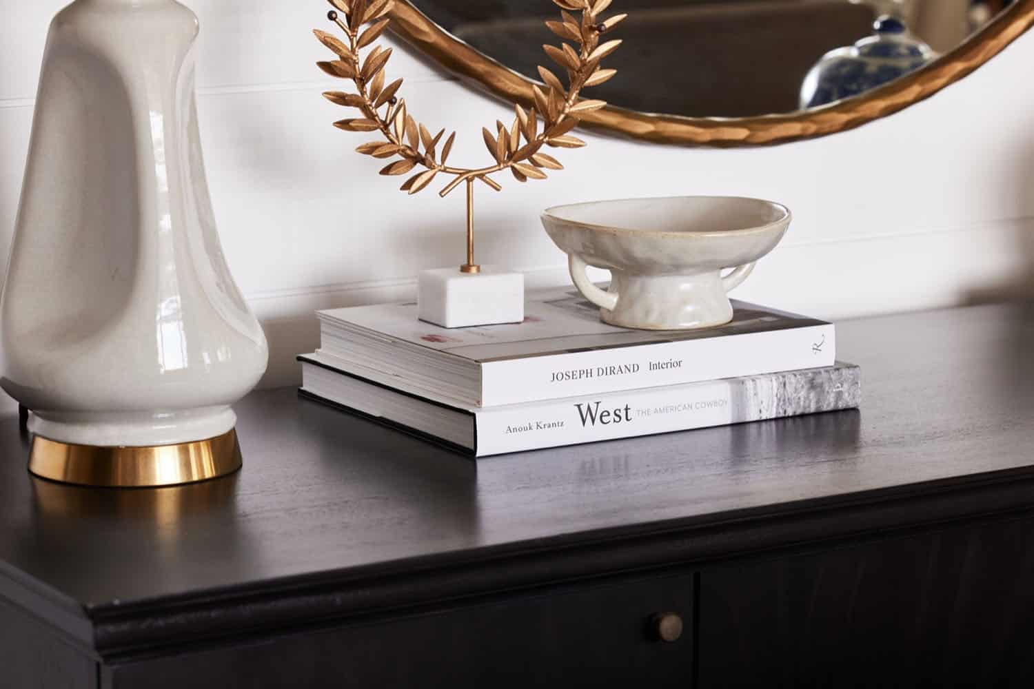A black and gold vase sits on a black table.