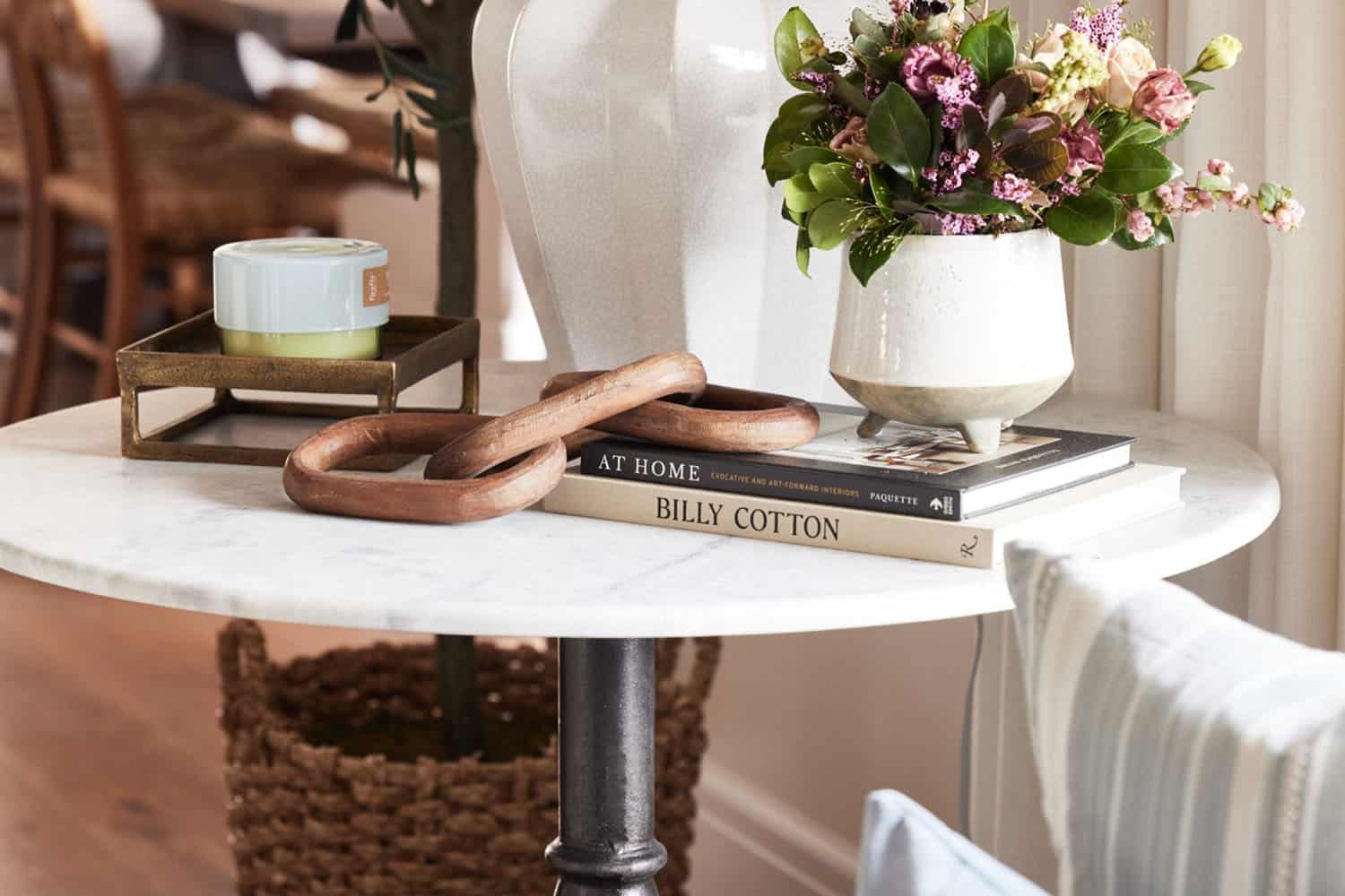 A vase of flowers sits on a table next to a book.