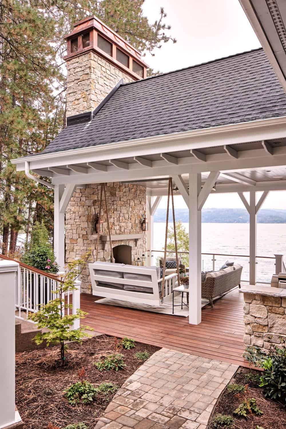 A covered porch with a fireplace and a patio.
