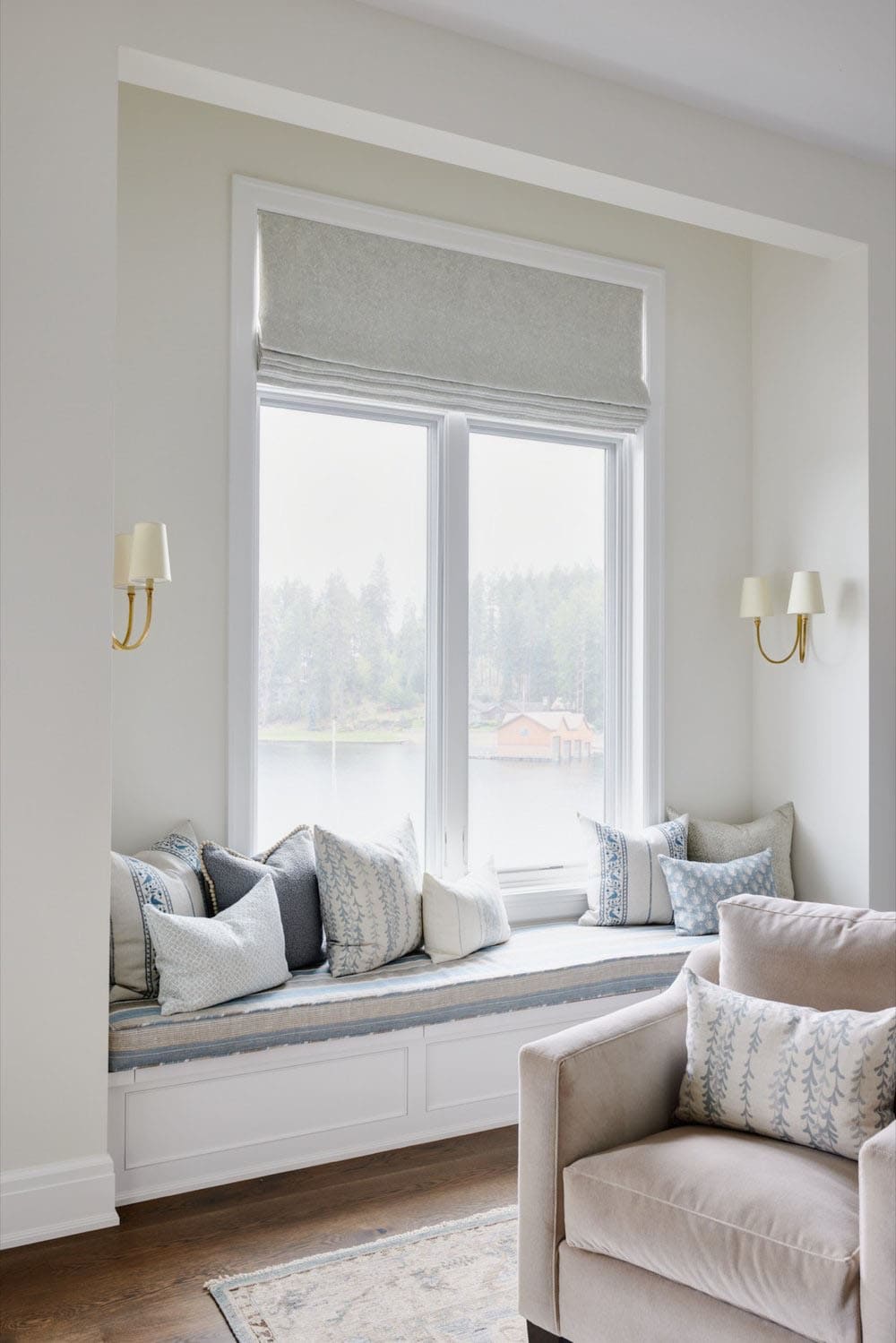 A bedroom with a window seat and reading chair.