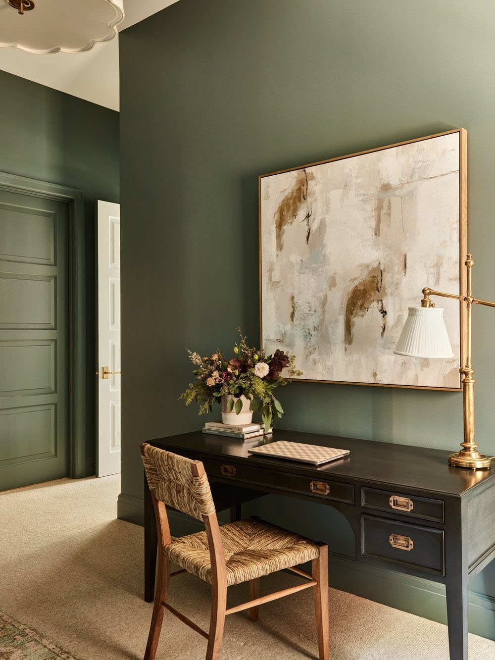 A home office with green walls and a desk.