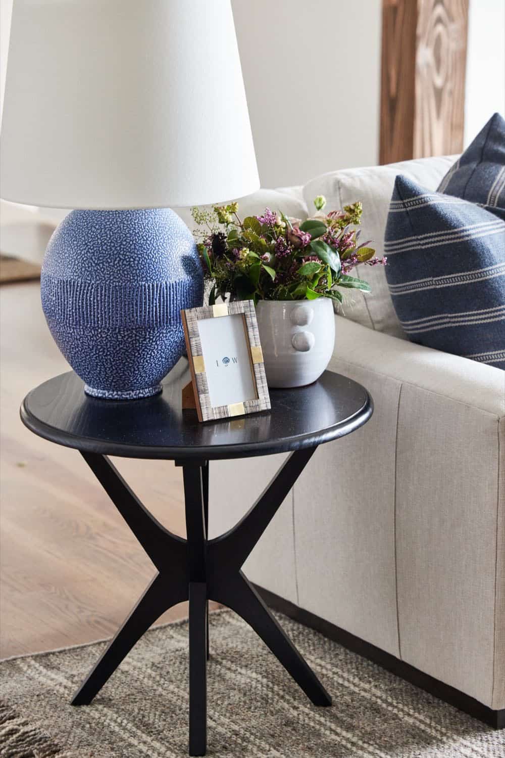 A small table with a lamp and a vase on it.