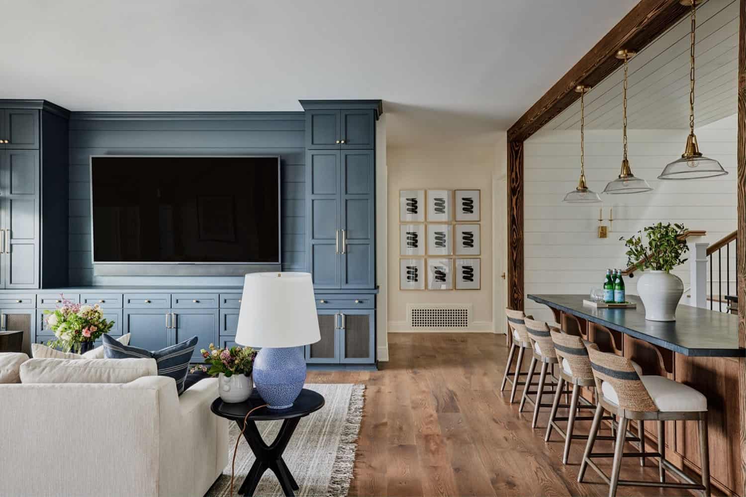 A family room with blue cabinets and a bar.