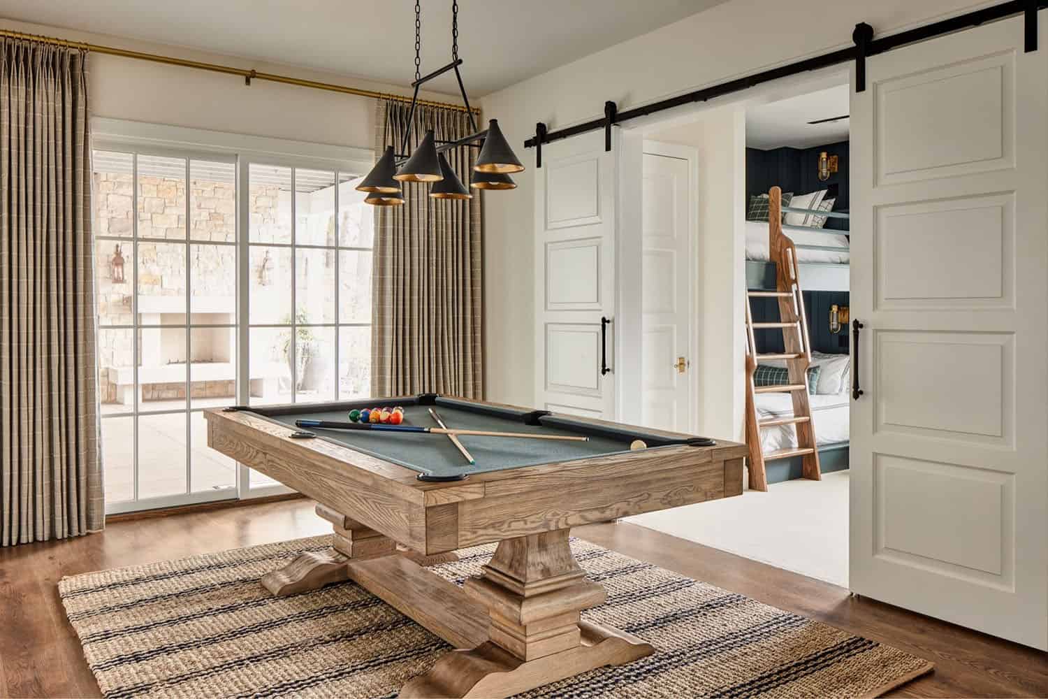 A pool table in a room with sliding doors.