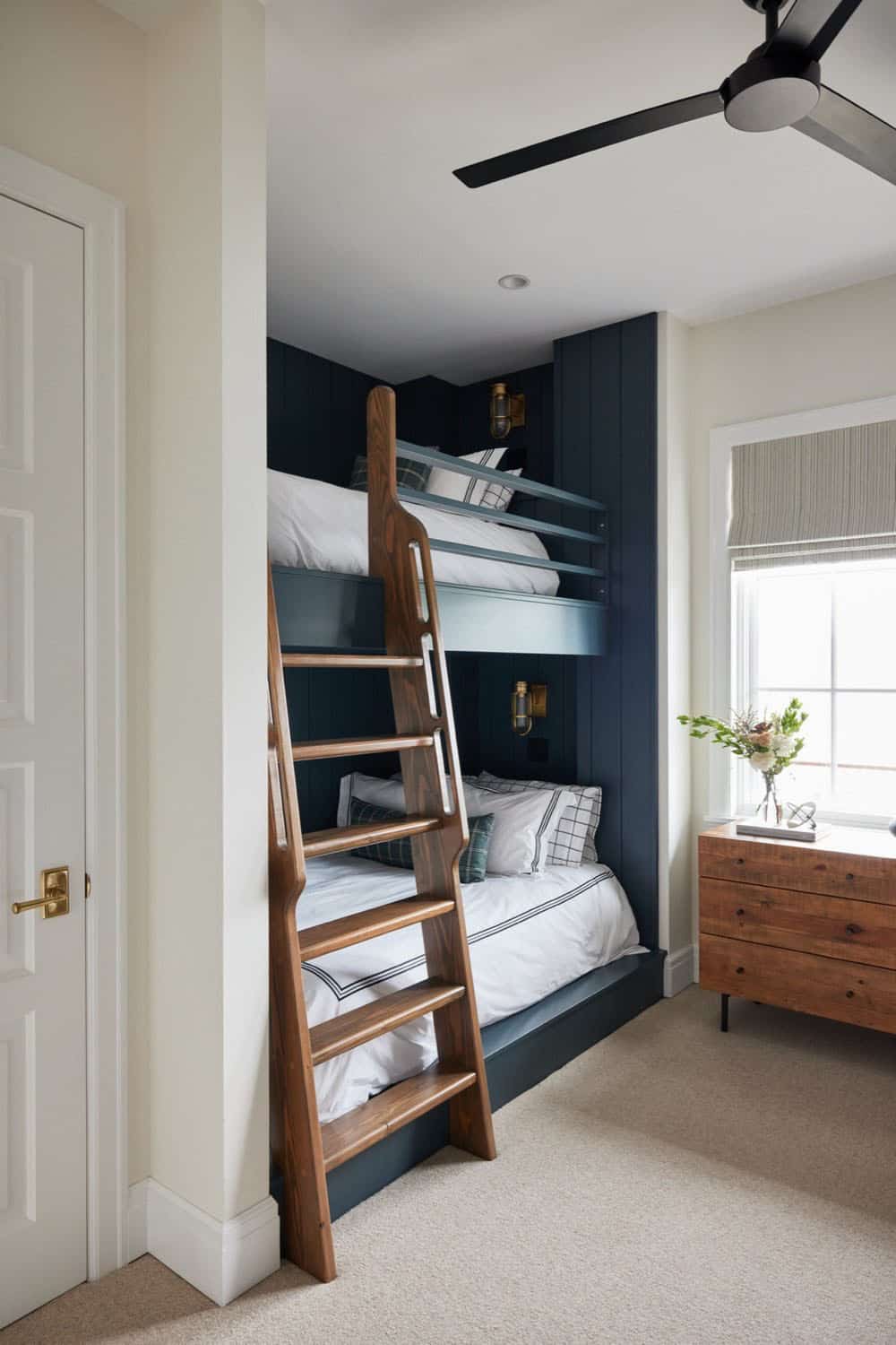 A bedroom with bunk beds and a dresser.