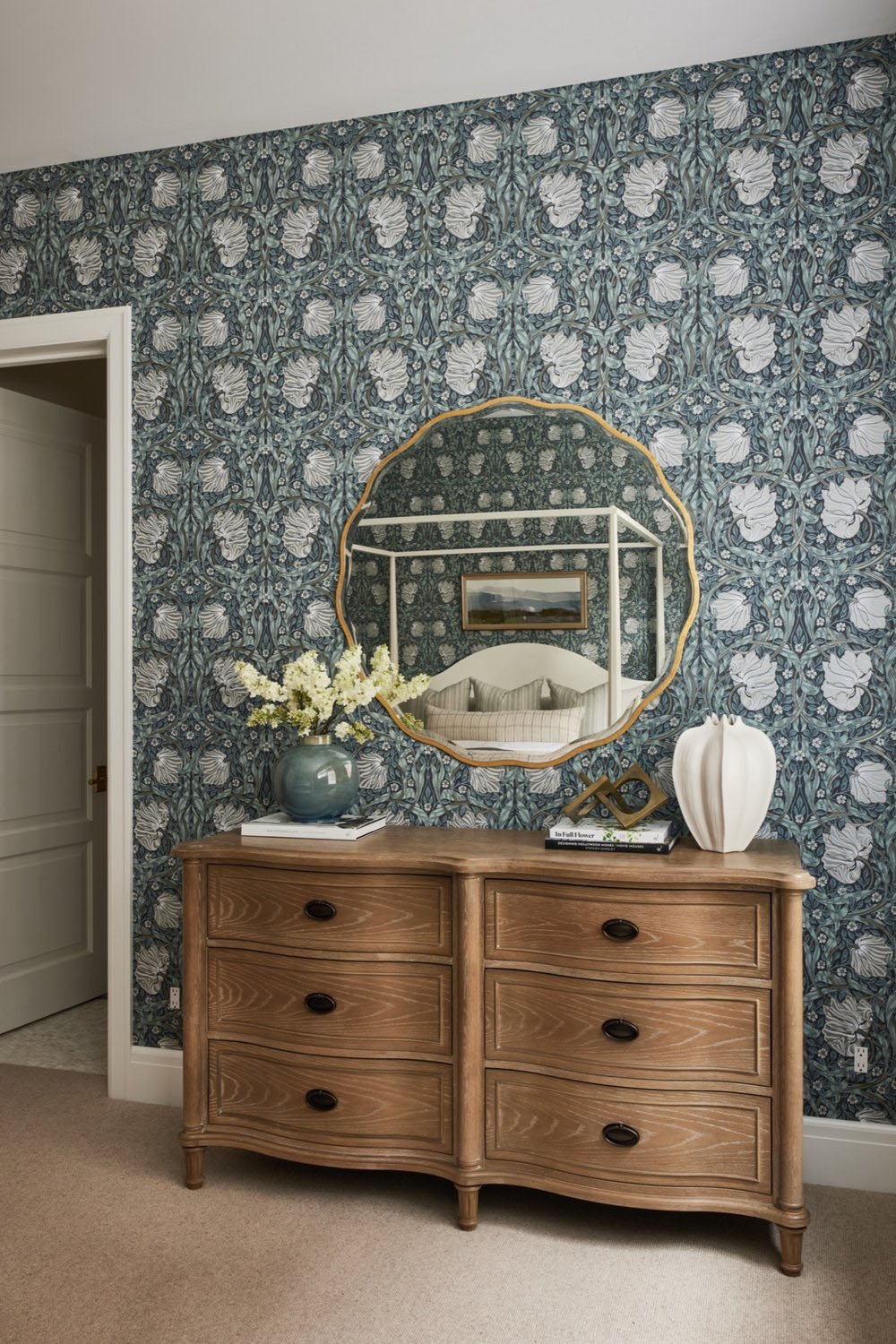 A bedroom with a mirror and wallpaper.