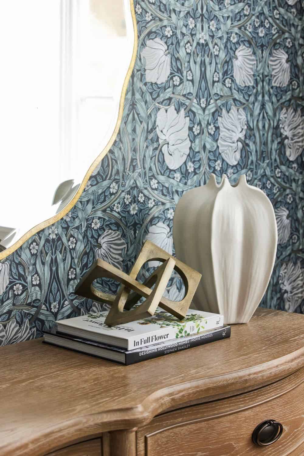 A blue and white floral wallpaper is on the wall.