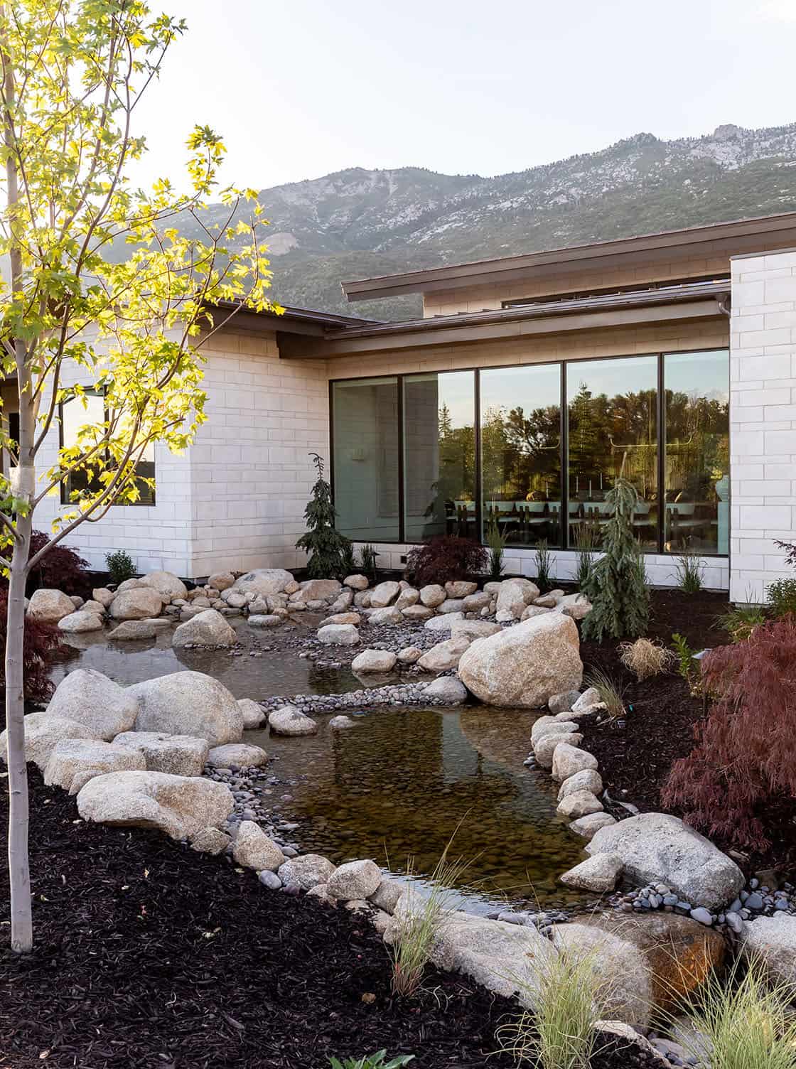 contemporary mountain home exterior with a waterfall