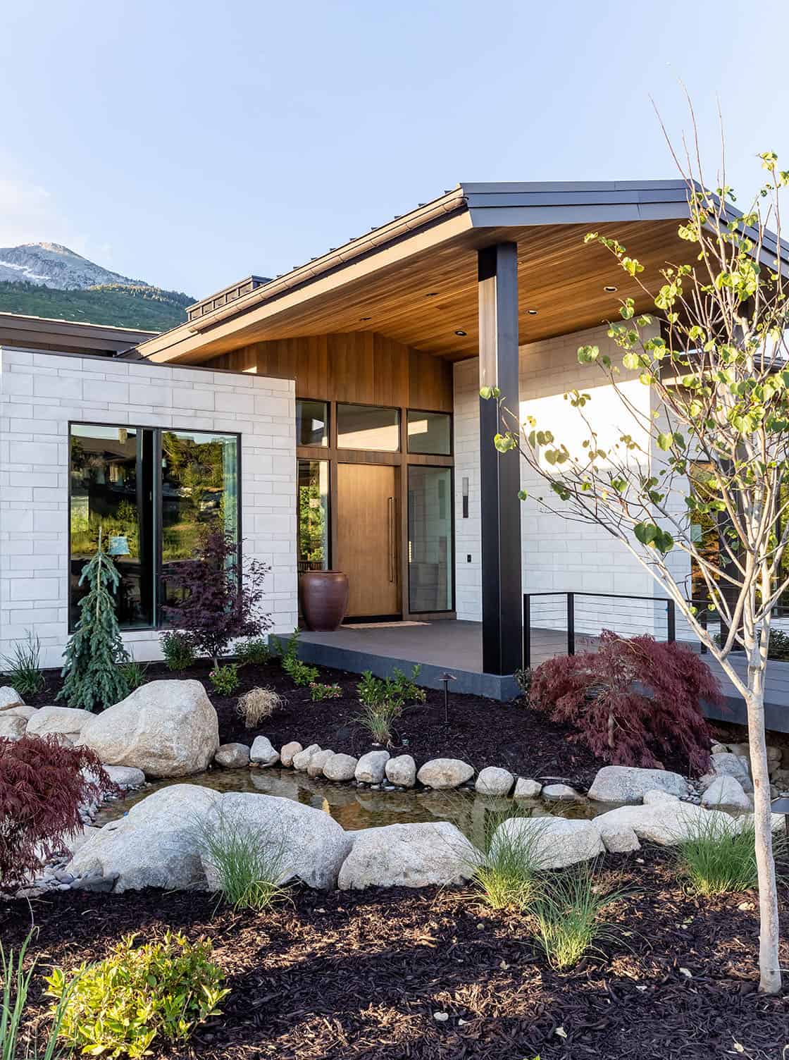 contemporary mountain home exterior with a waterfall