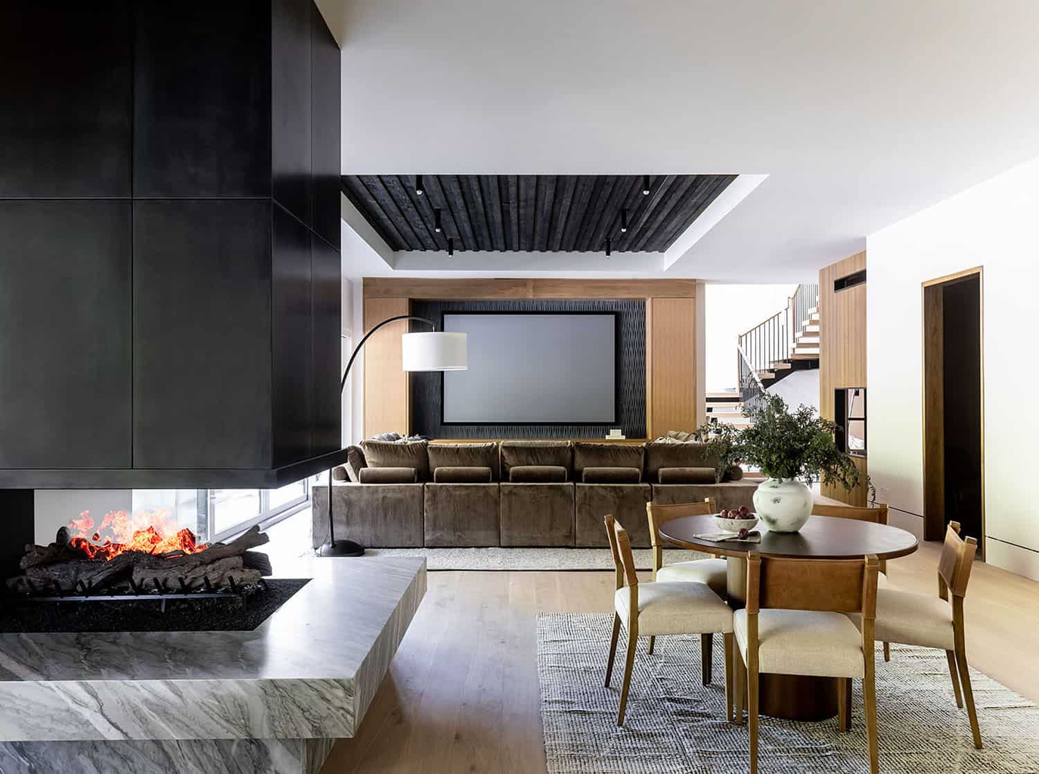 contemporary lower-level family room with a three-sided fireplace