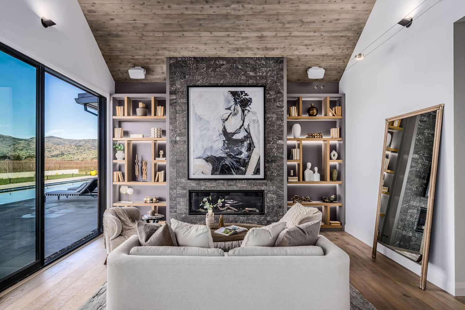 contemporary bedroom itting area with a fireplace and built-in book shelves