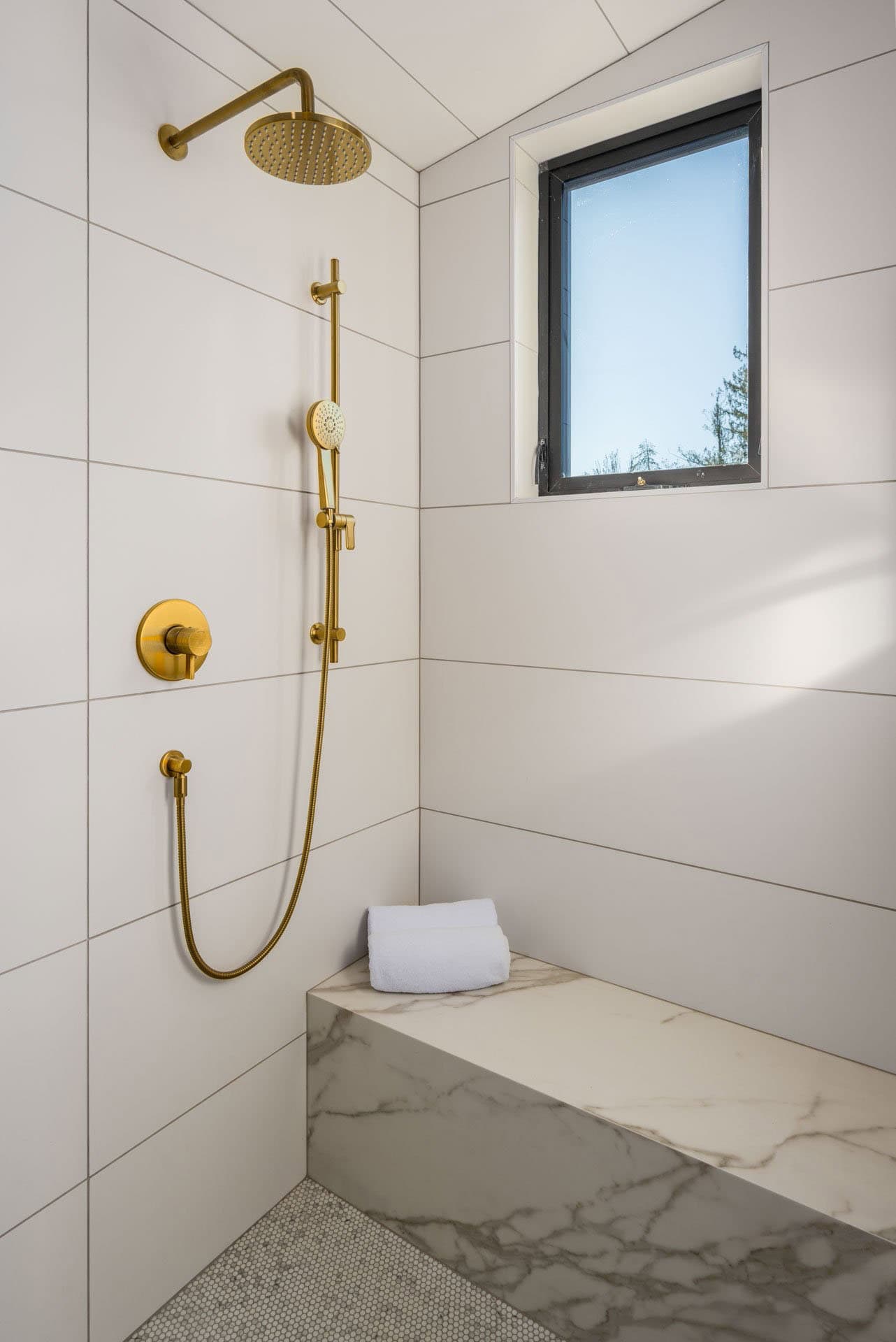 contemporary bathroom shower with white tiles and an integrated bench