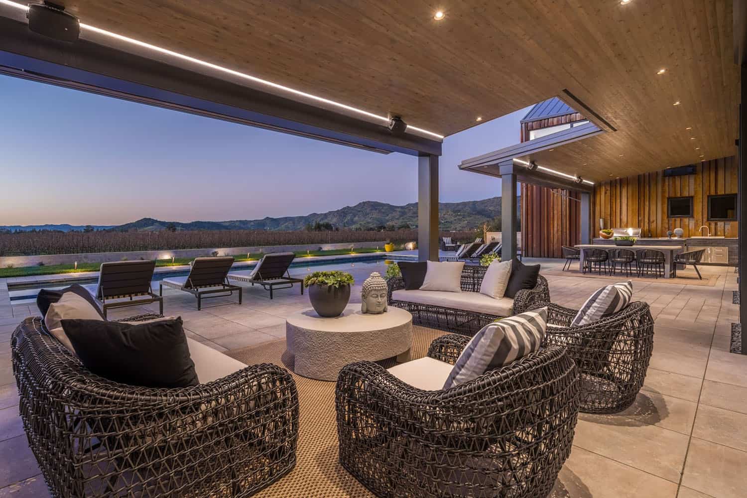 contemporary vineyard home covered patio with outdoor furniture at dusk
