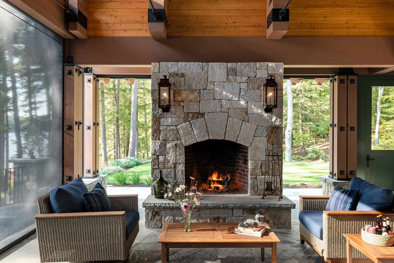 rustic covered porch with a fireplace
