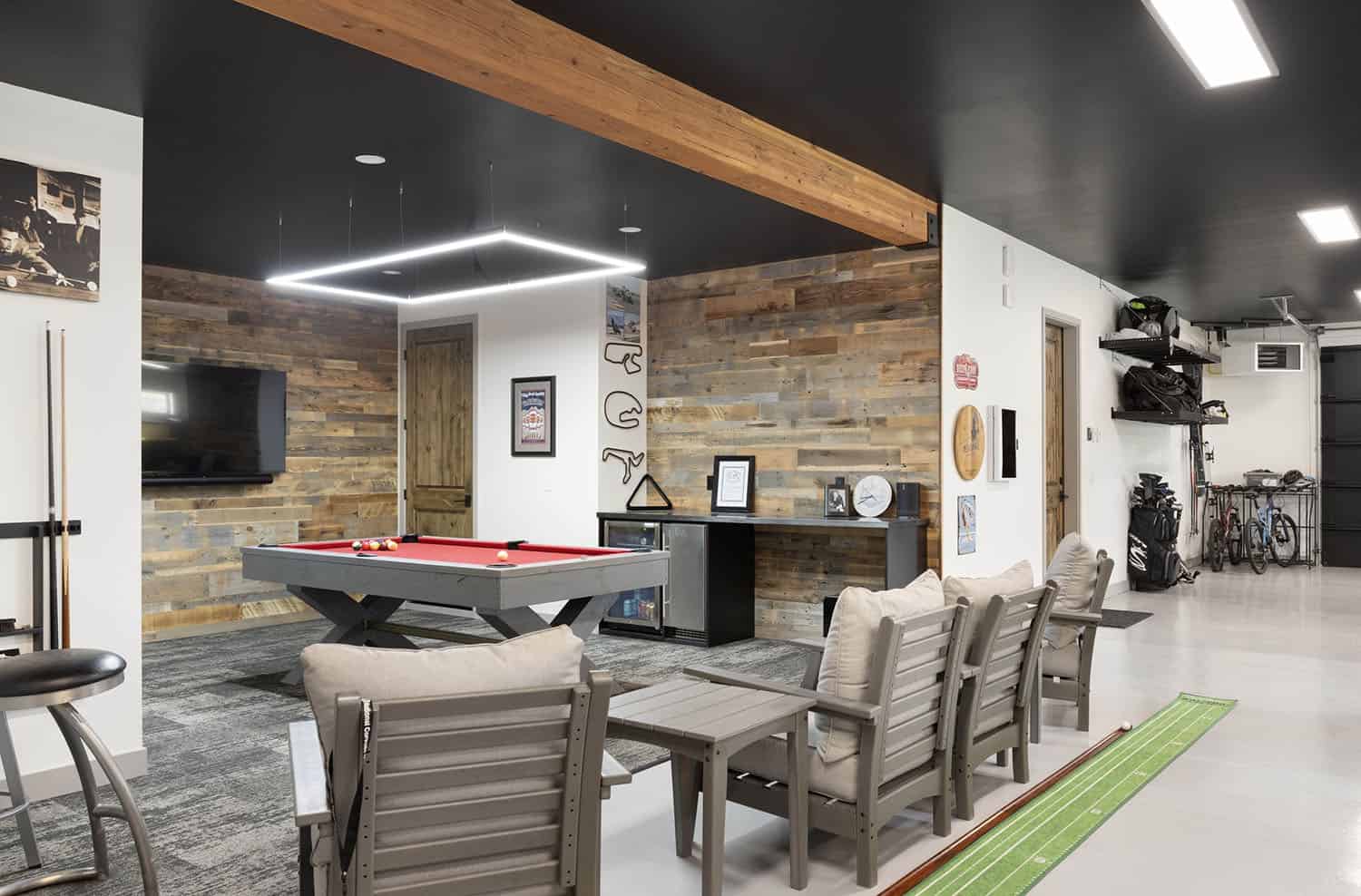 A game room with a pool table and chairs.