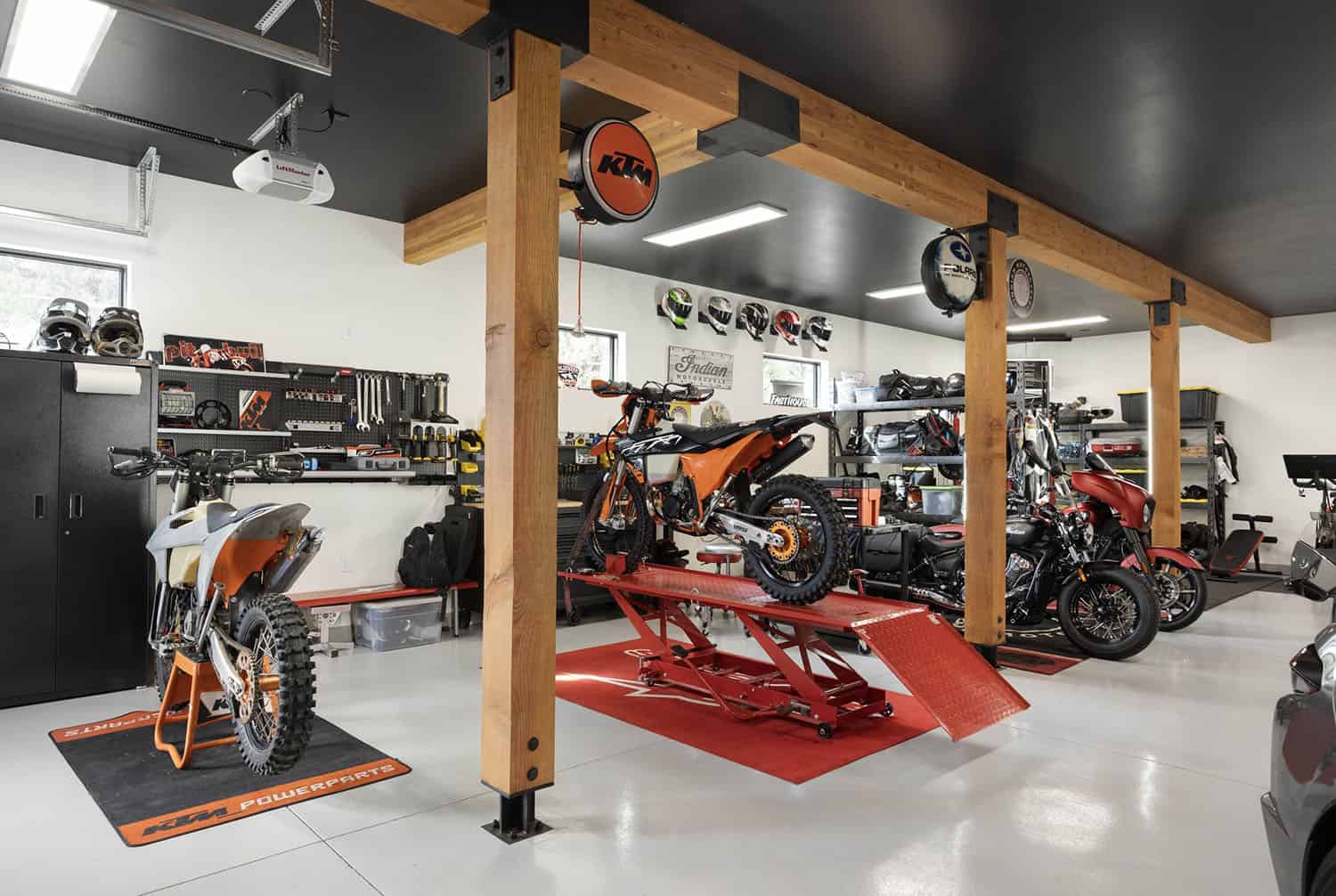 A motorcycle garage with a motorcycle on the floor.