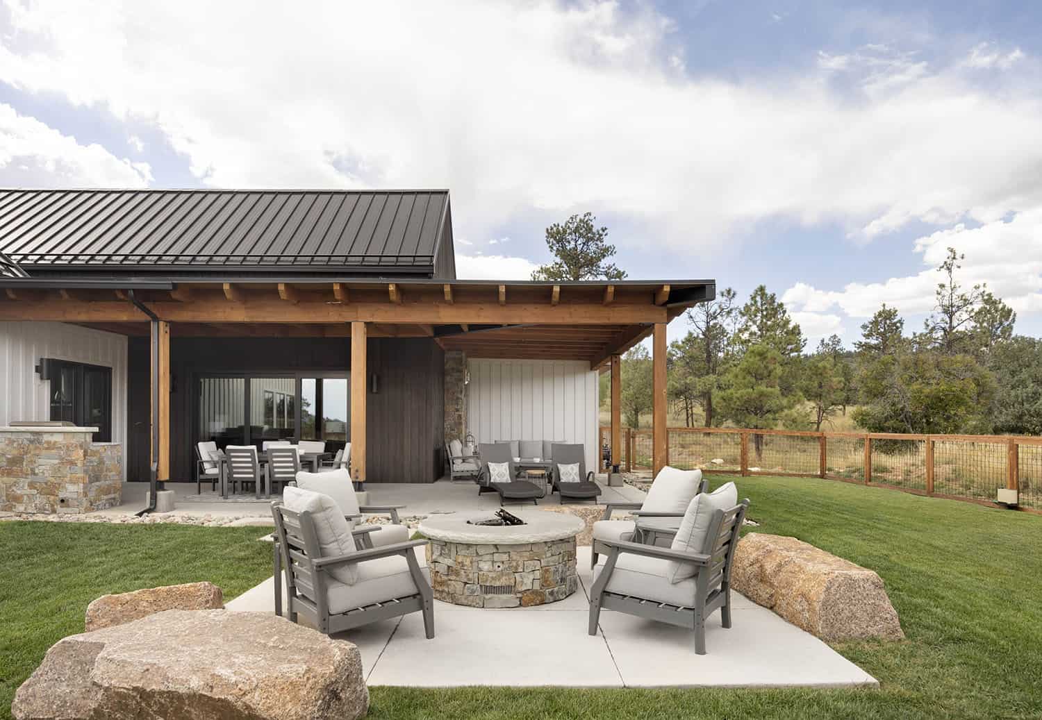 modern farmhouse home exterior with a patio and fire pit