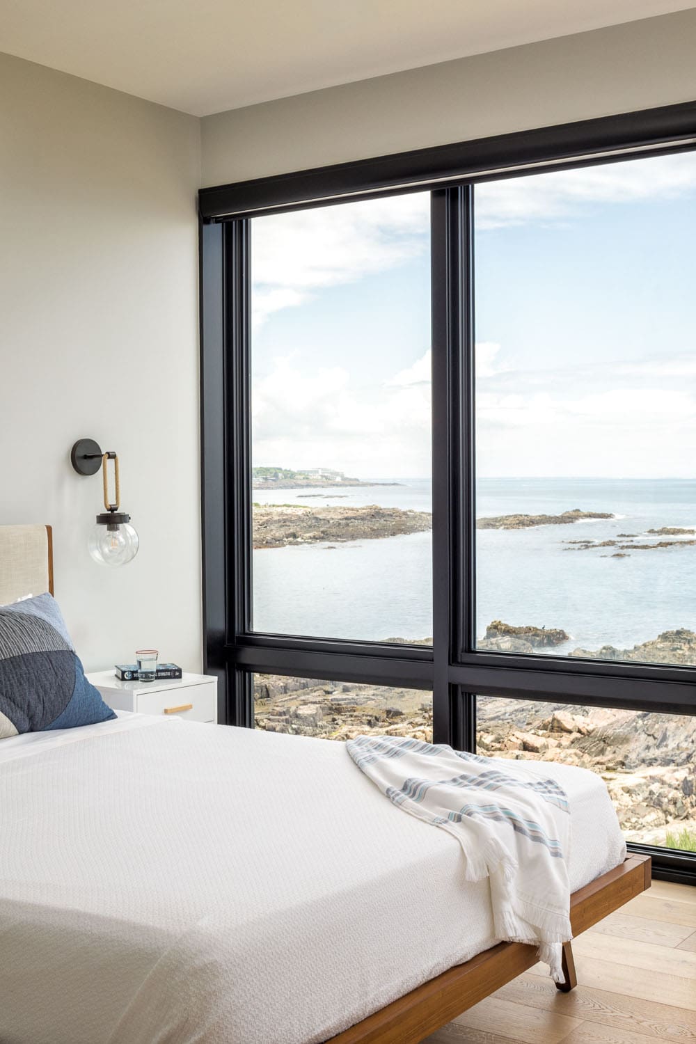 modern japandi-inspired bedroom with a large window and a water view
