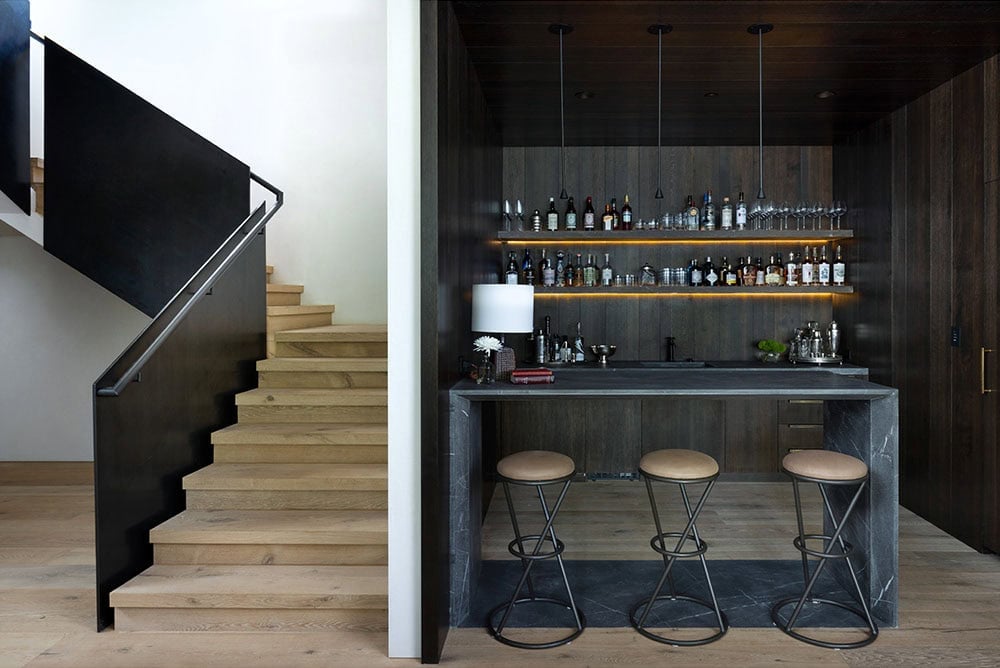 contemporary home bar with a staircase