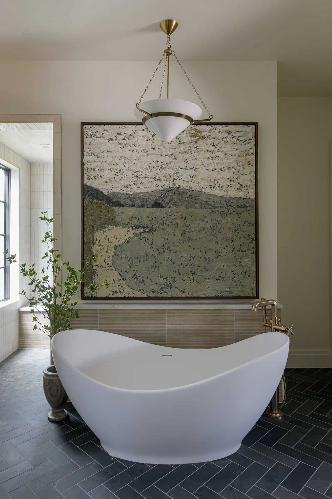 modern bathroom with a soaking tub and large artwork