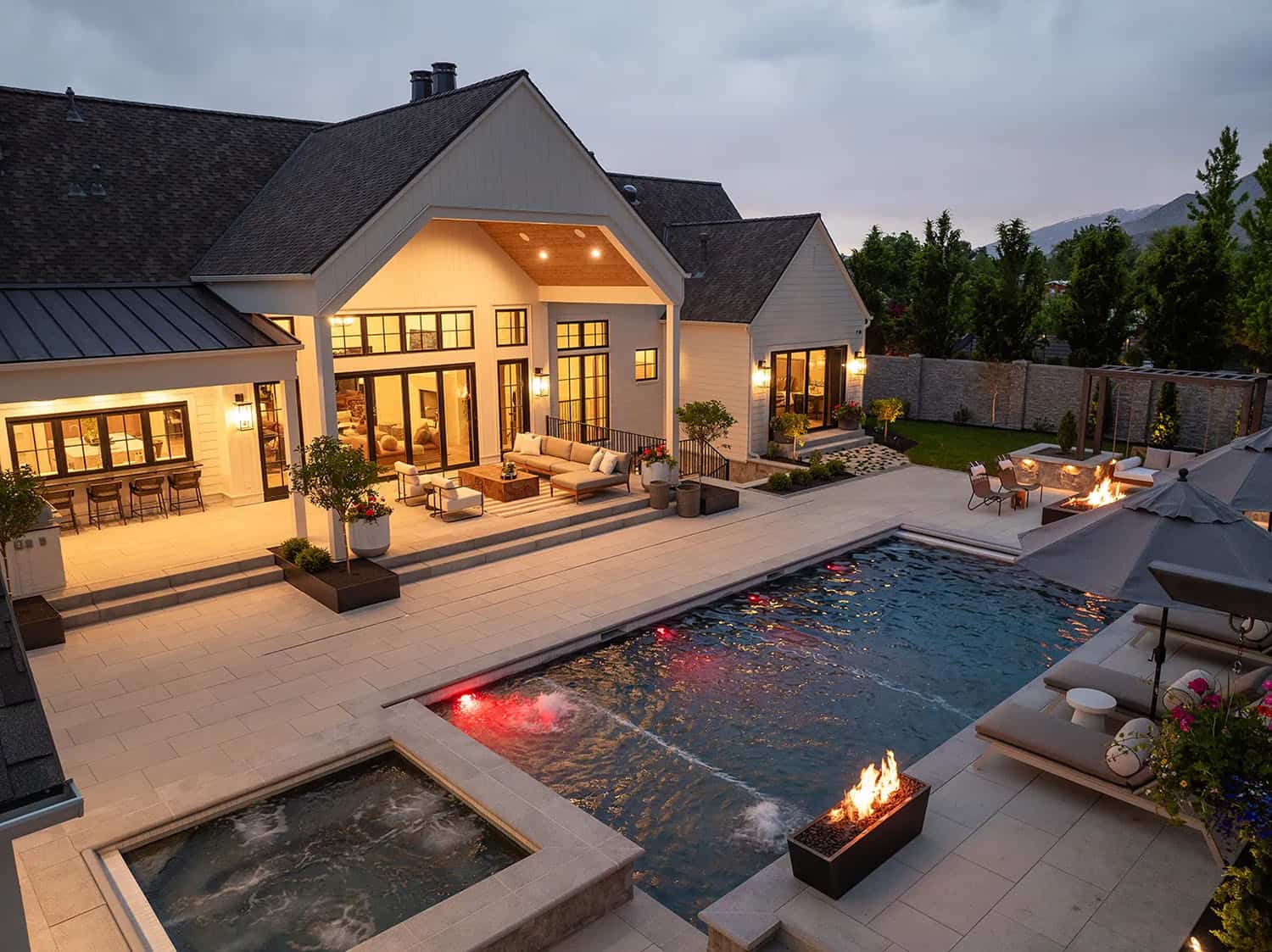european style home exterior with a pool at dusk