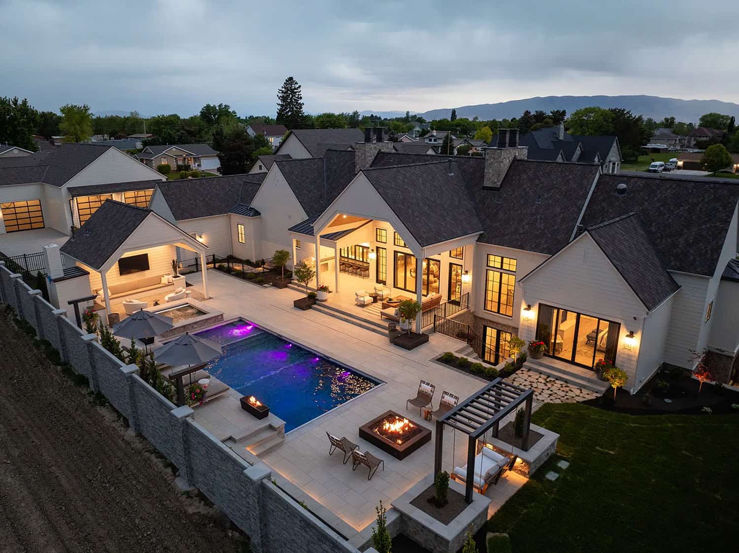 european style home exterior with a pool at dusk