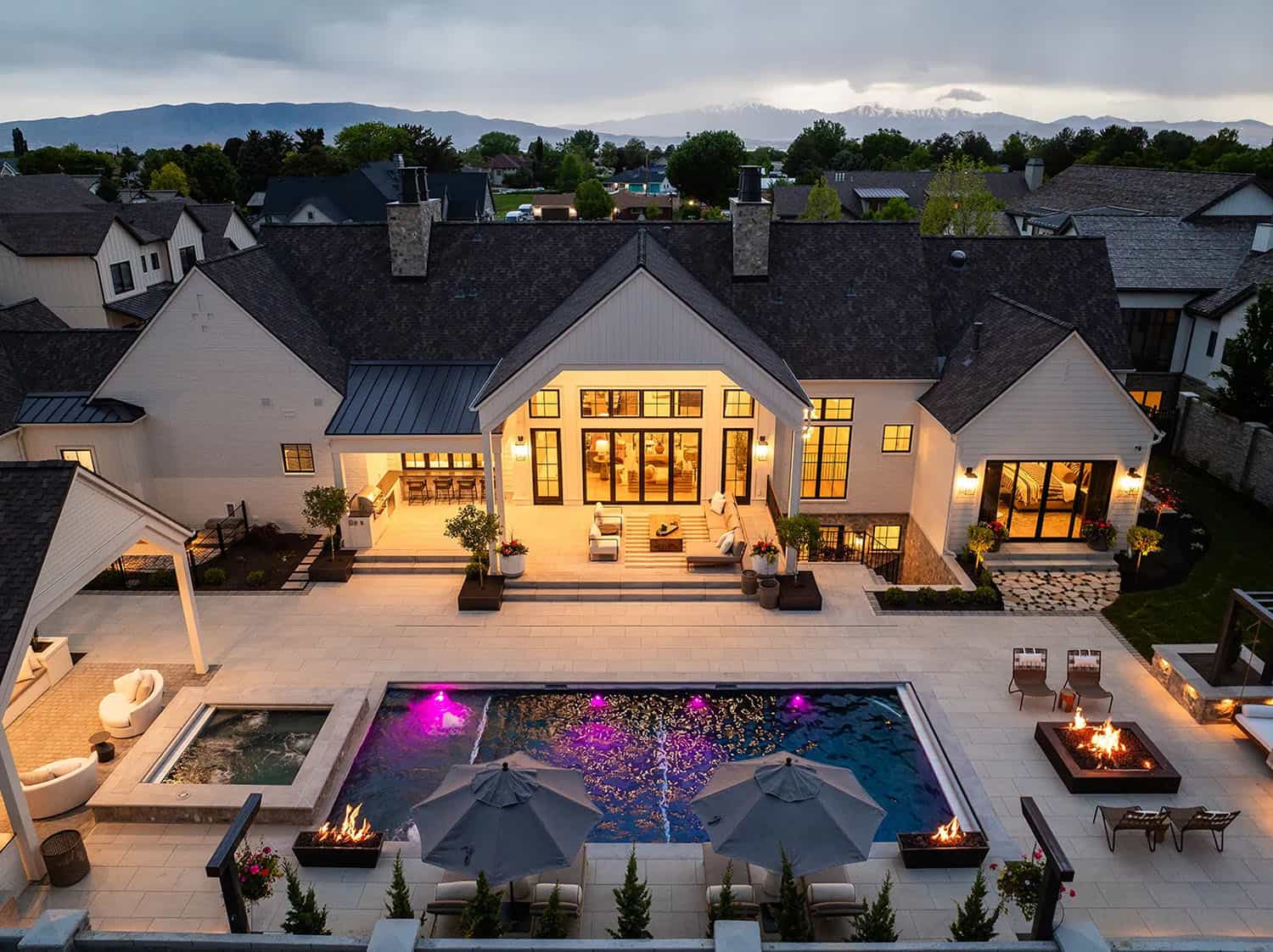 european style home exterior with a pool at dusk