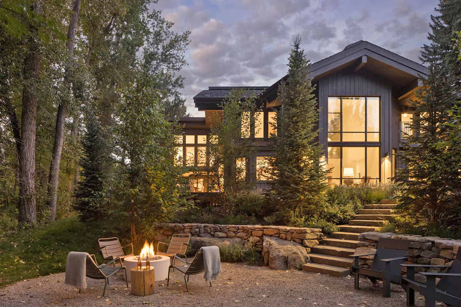 modern mountain home exterior backyard view with a fire pit