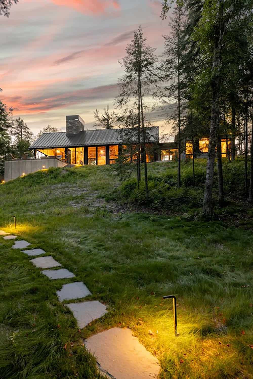modern cabin exterior at dusk with a stone pathway