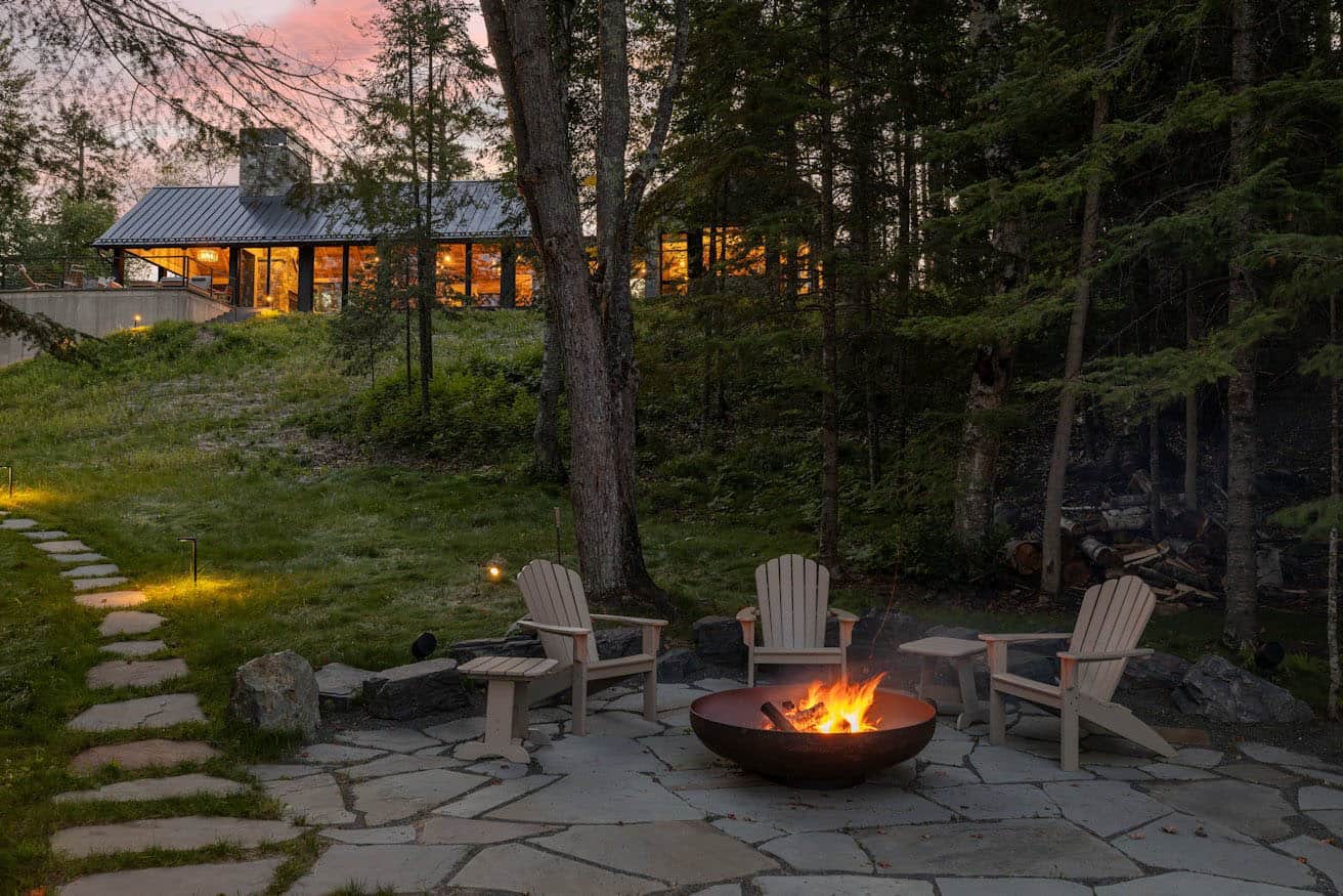 modern cabin exterior at dusk with a fire pit