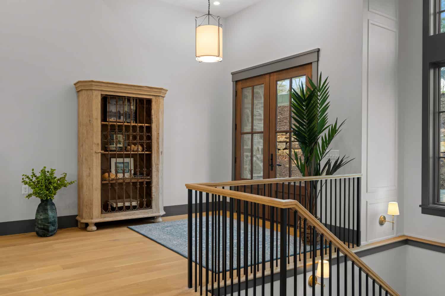 A hallway with a staircase and a bookcase.