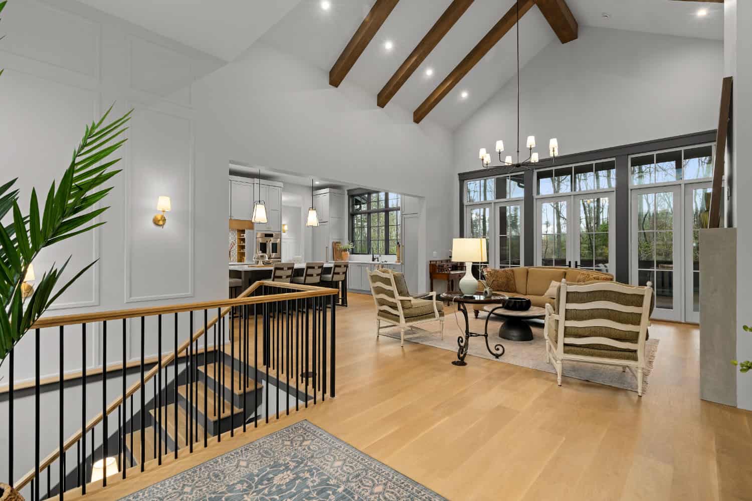A living room with a staircase and a large window.