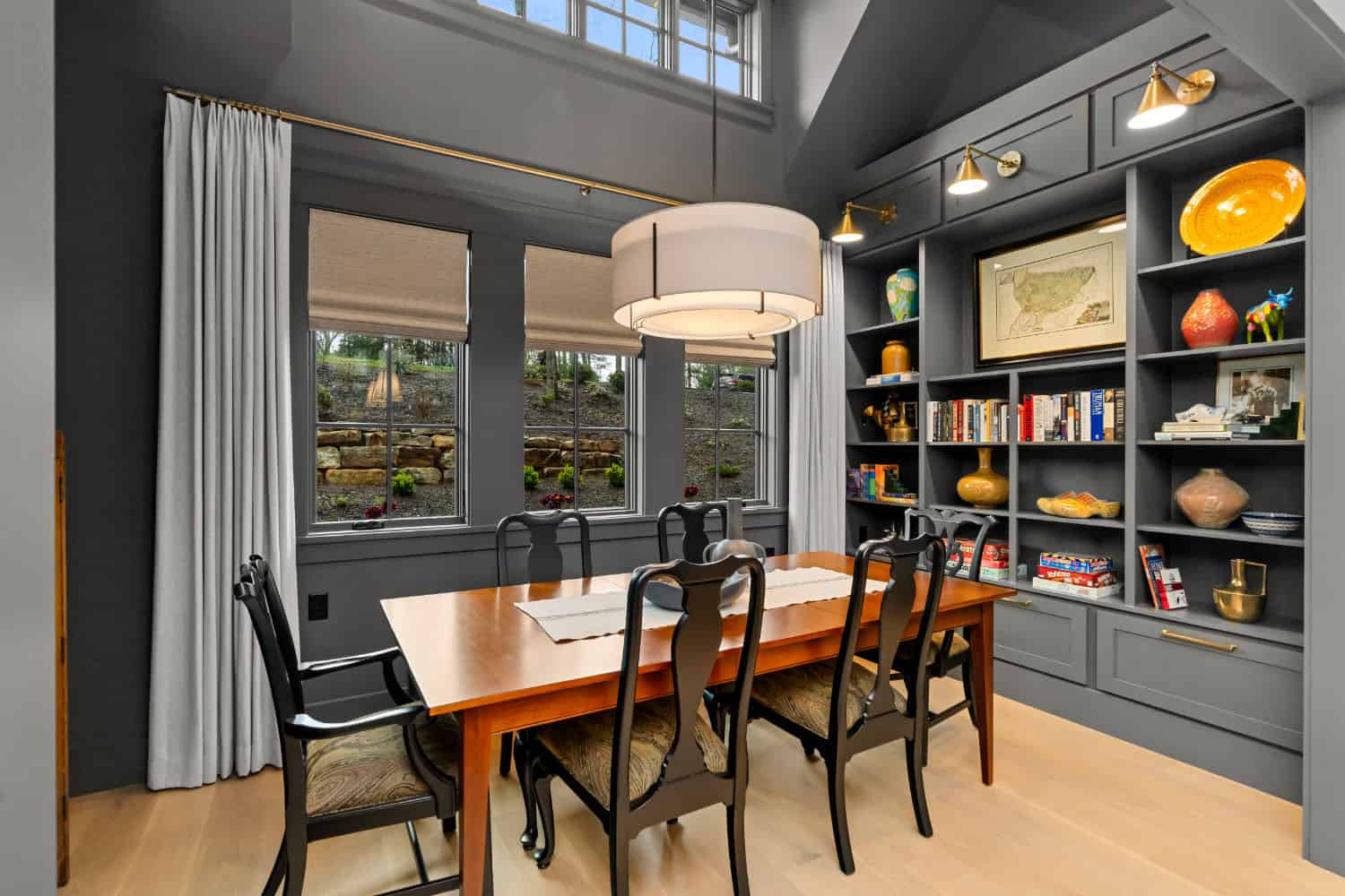 A dining room with a bookcase and a table.