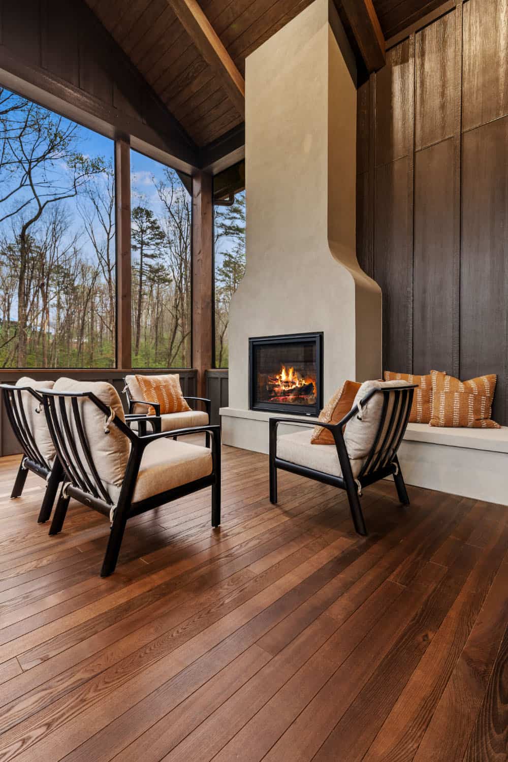 modern screened porch with a fireplace and outdoor furniture