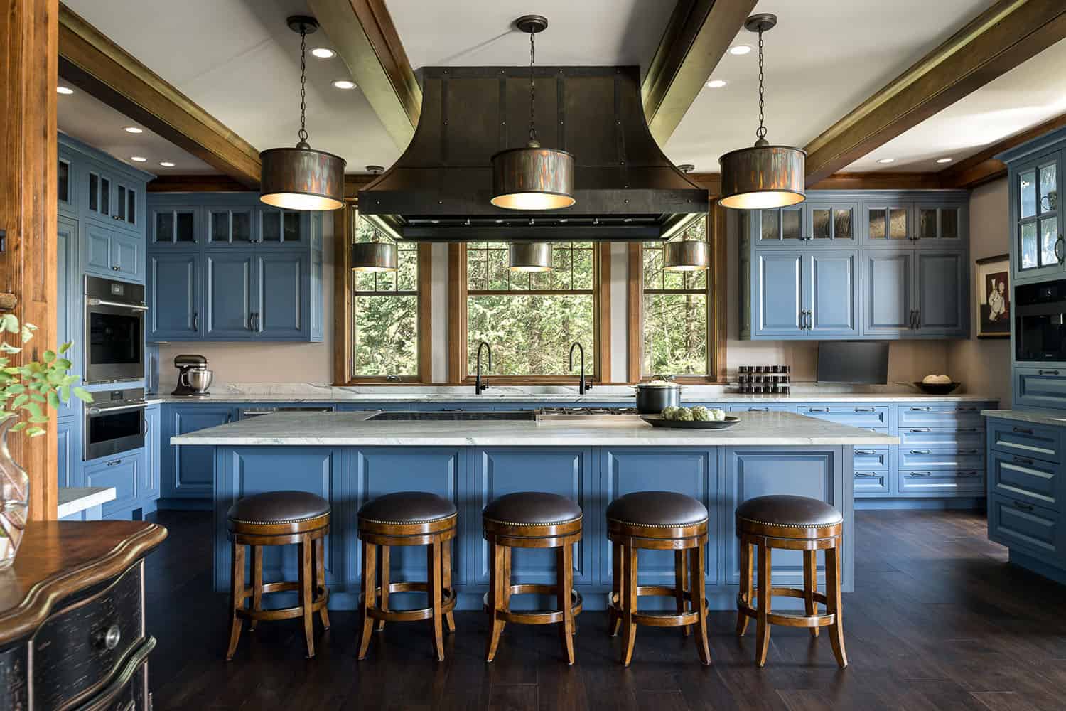 A kitchen with blue cabinets and stools
