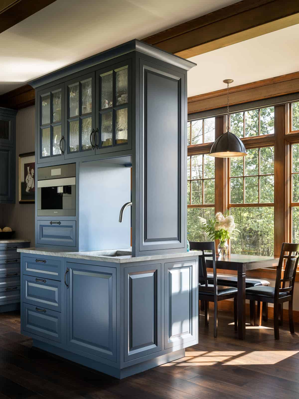 A kitchen with blue cabinets and wood floors