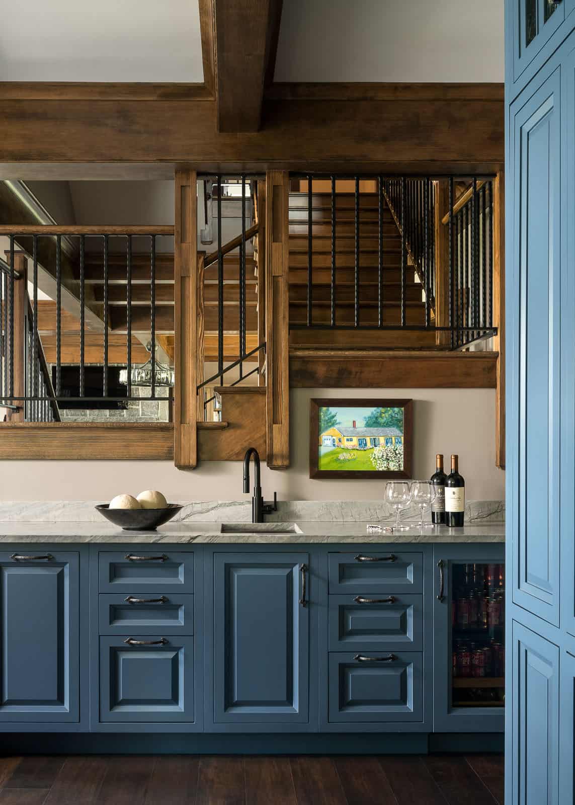 A kitchen with blue cabinets and wooden beams