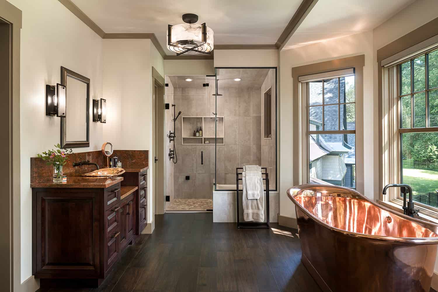 A bathroom with a copper tub and a large window