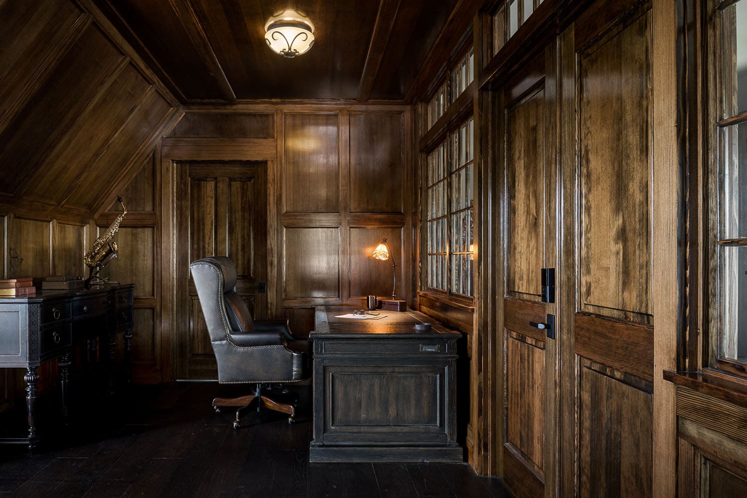 A home office with wooden paneling and a desk
