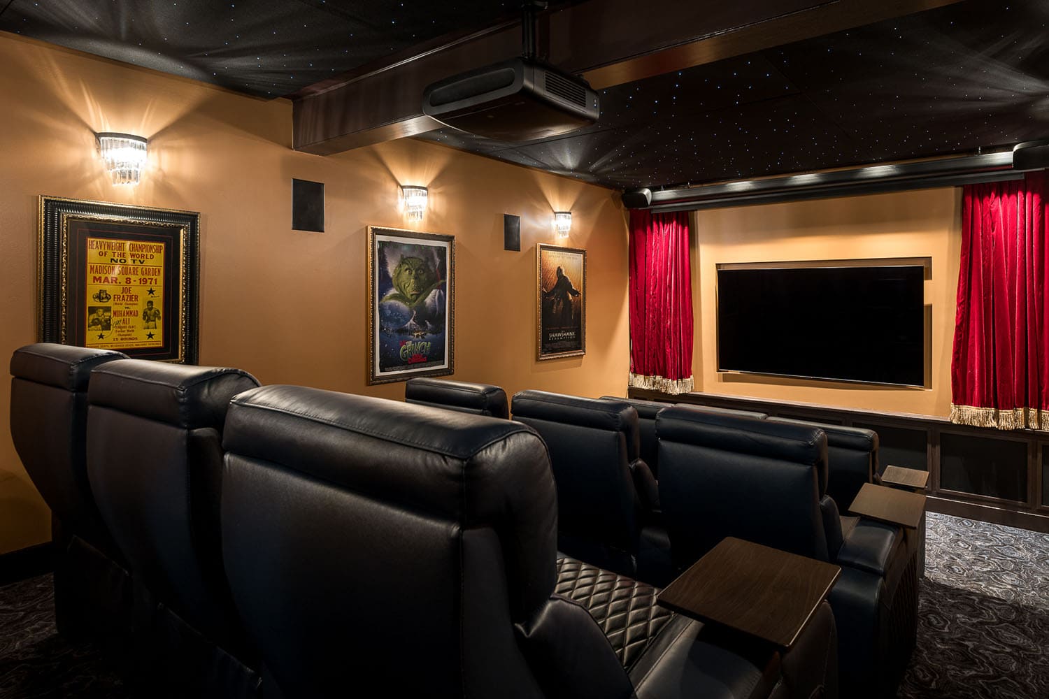 A home theater room with red curtains and black leather seats