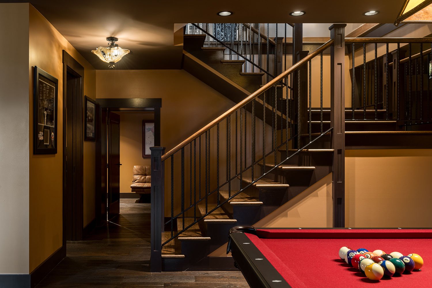 A pool table in a room with stairs