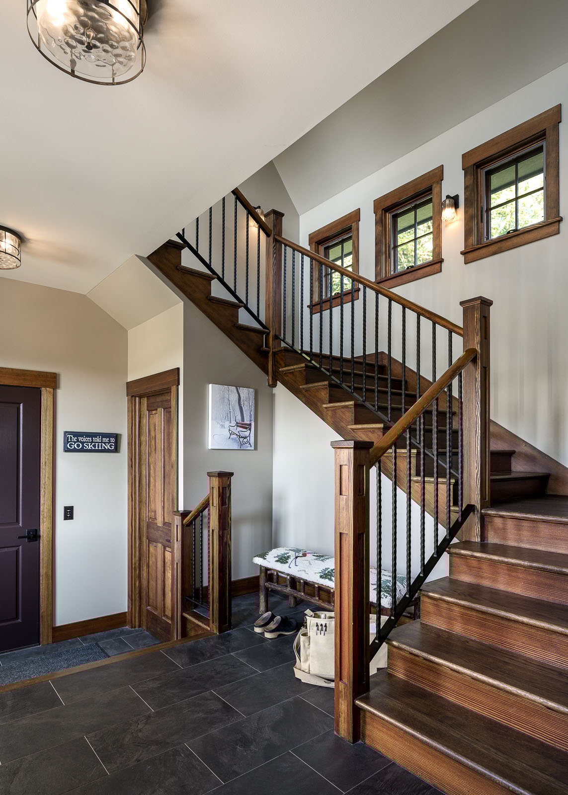 A foyer with wooden stairs and a light fixture