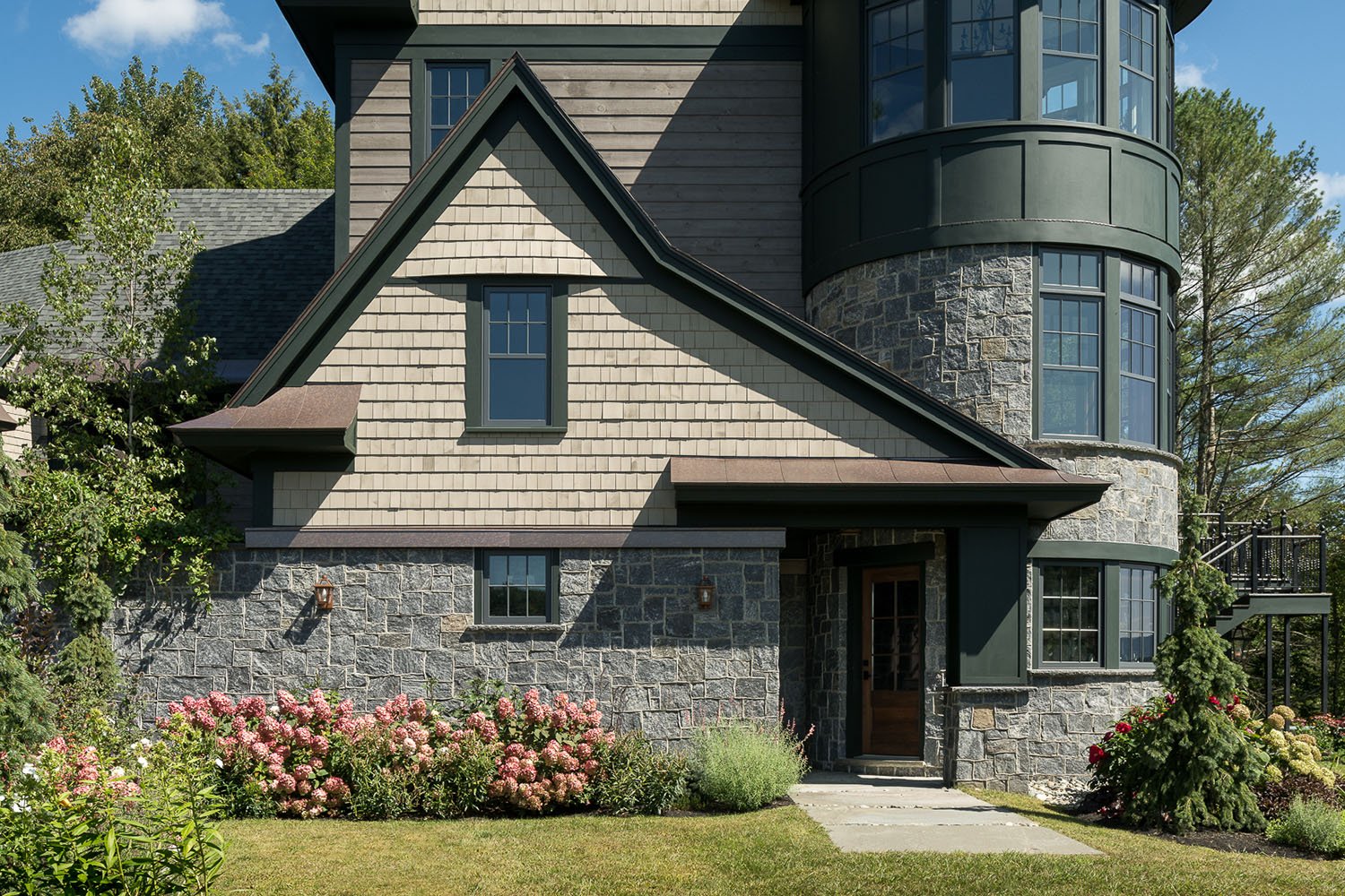A large home with a stone exterior and a wood front door