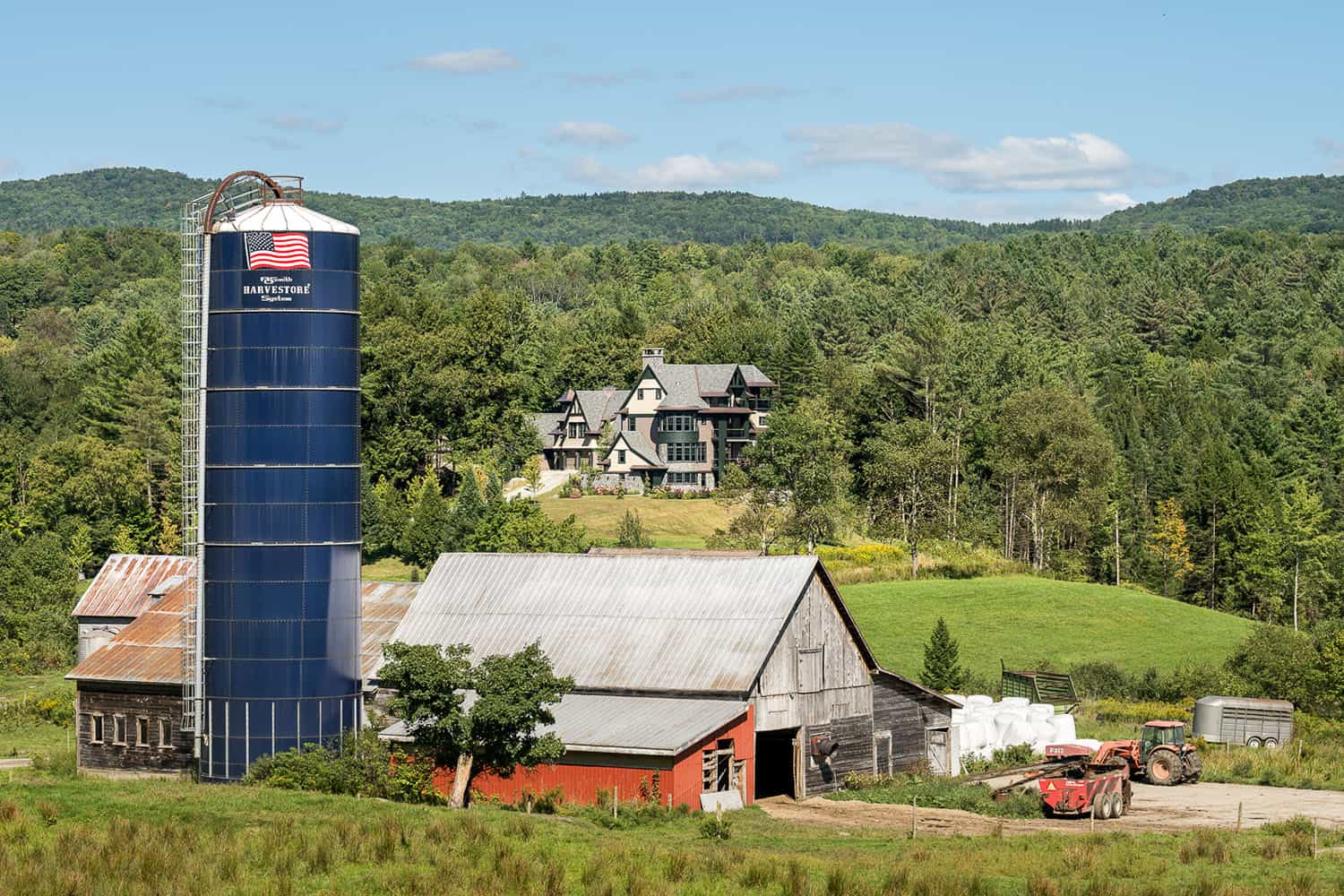 A farm with a silo and barn in the background