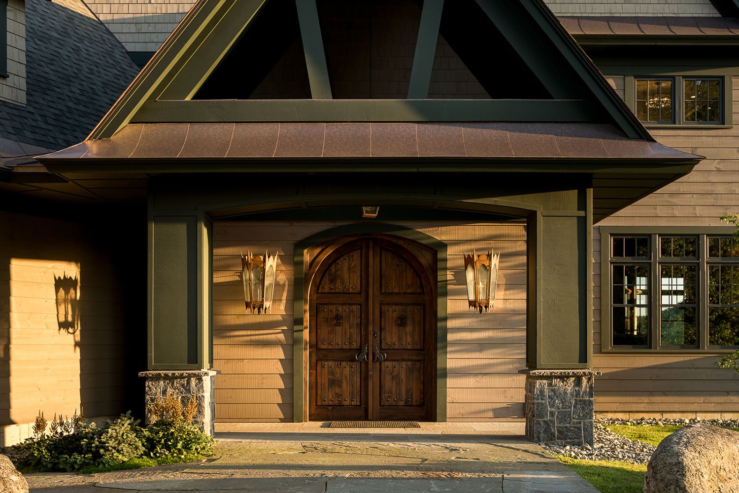 A beautiful home with wood siding and a wood entry door