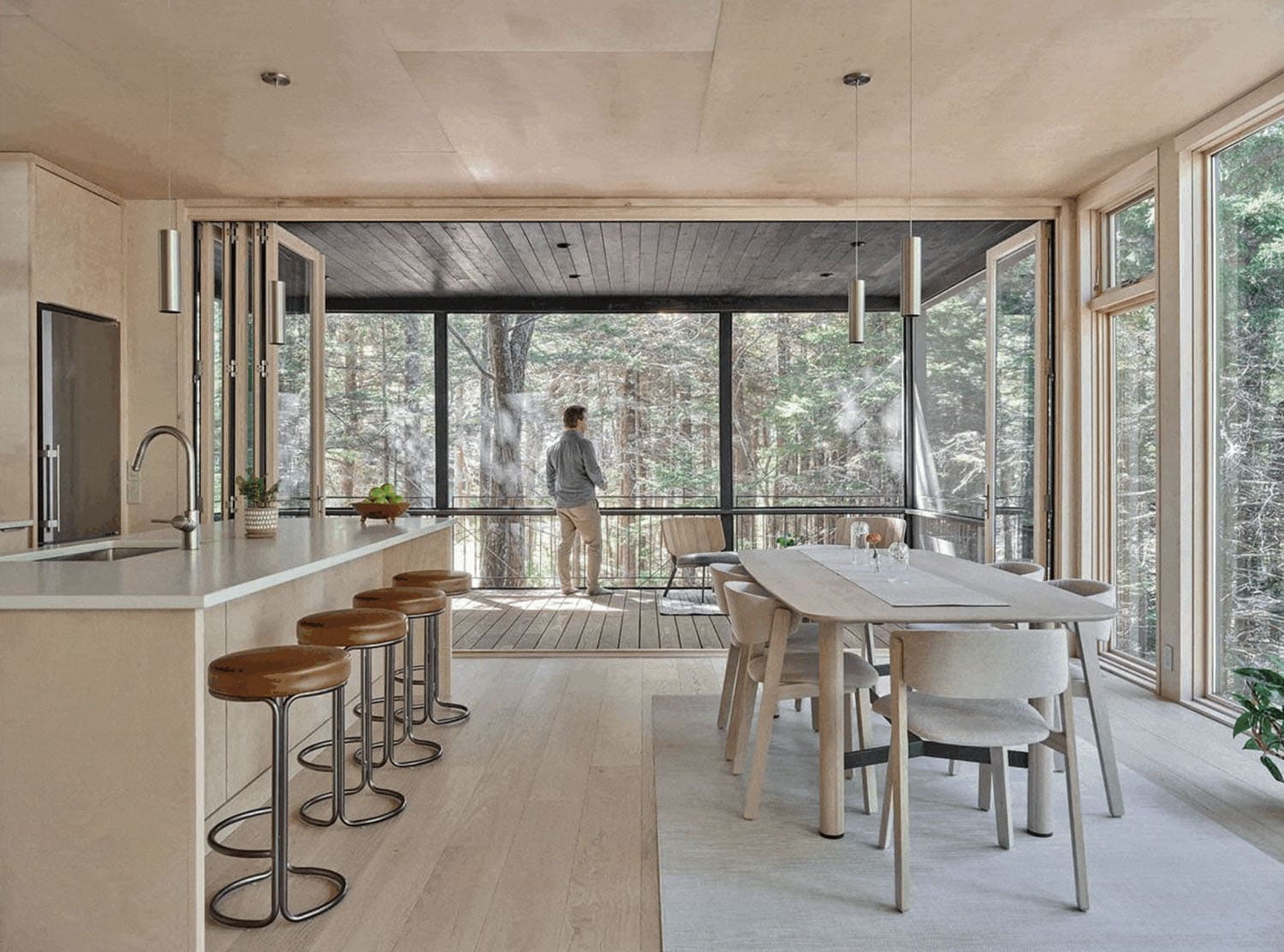 modern kitchen and dining room with sliding glass doors leading out to the covered deck
