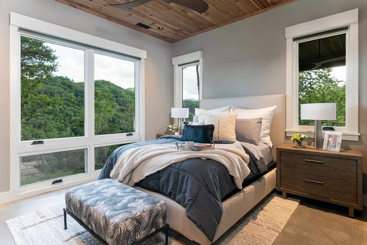 modern bedroom with a large window and mountain views
