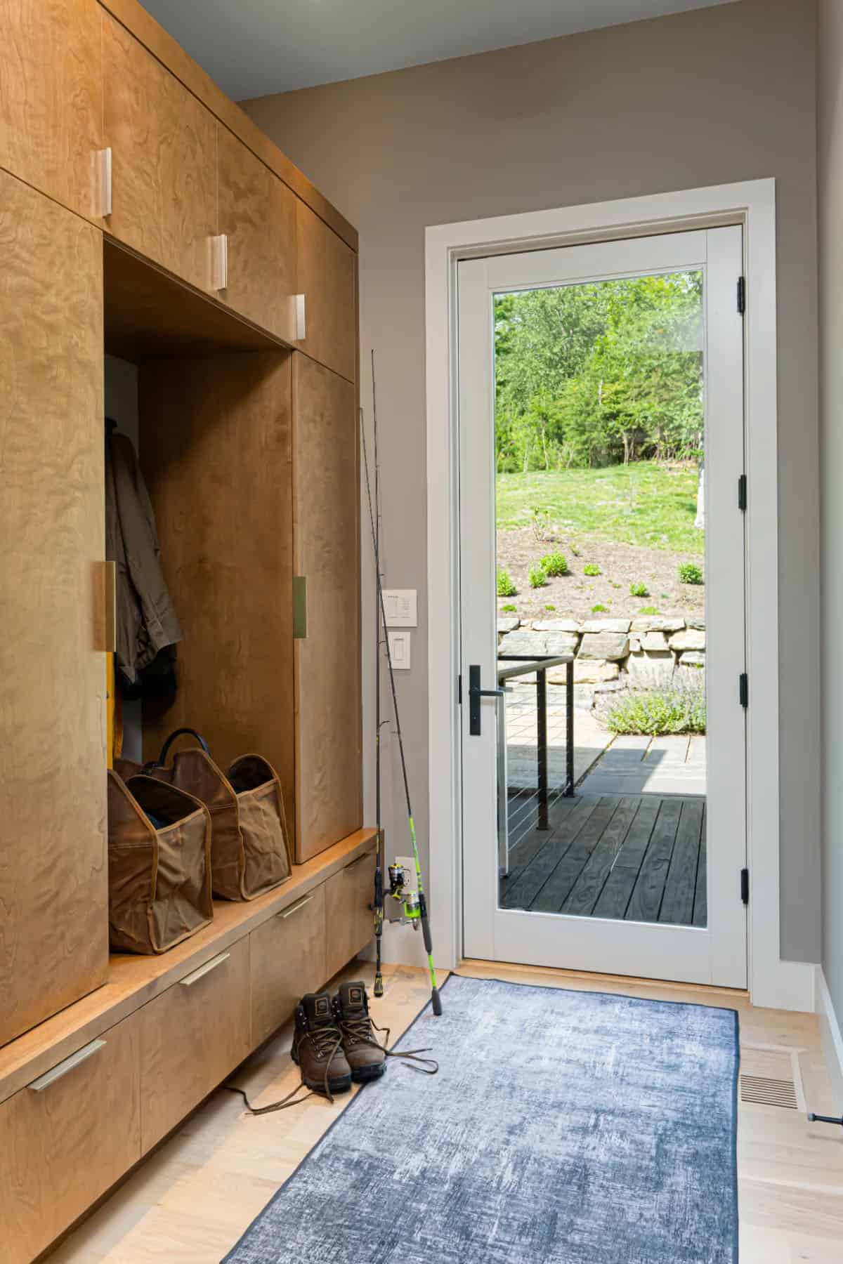 modern mudroom entry with a storage cabinet and bench